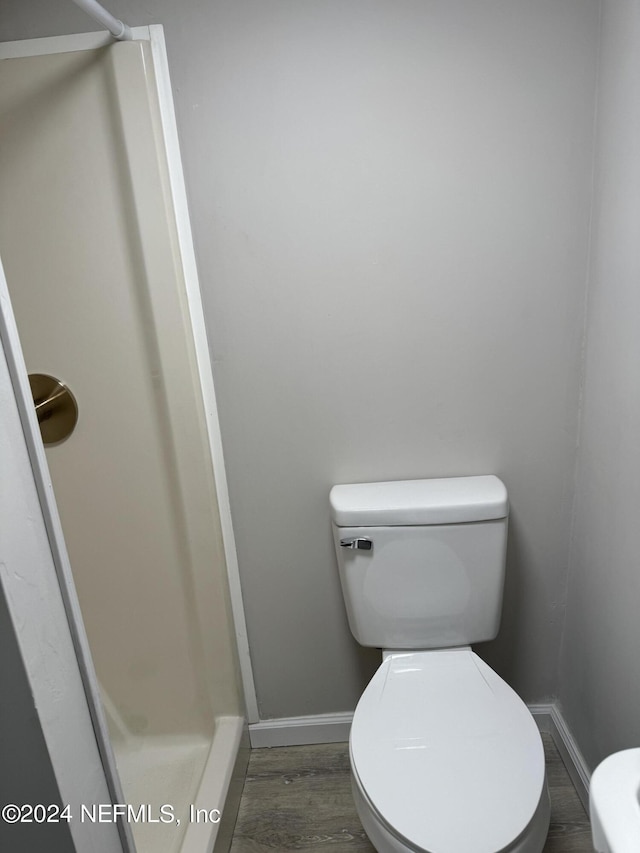 bathroom featuring wood-type flooring and toilet