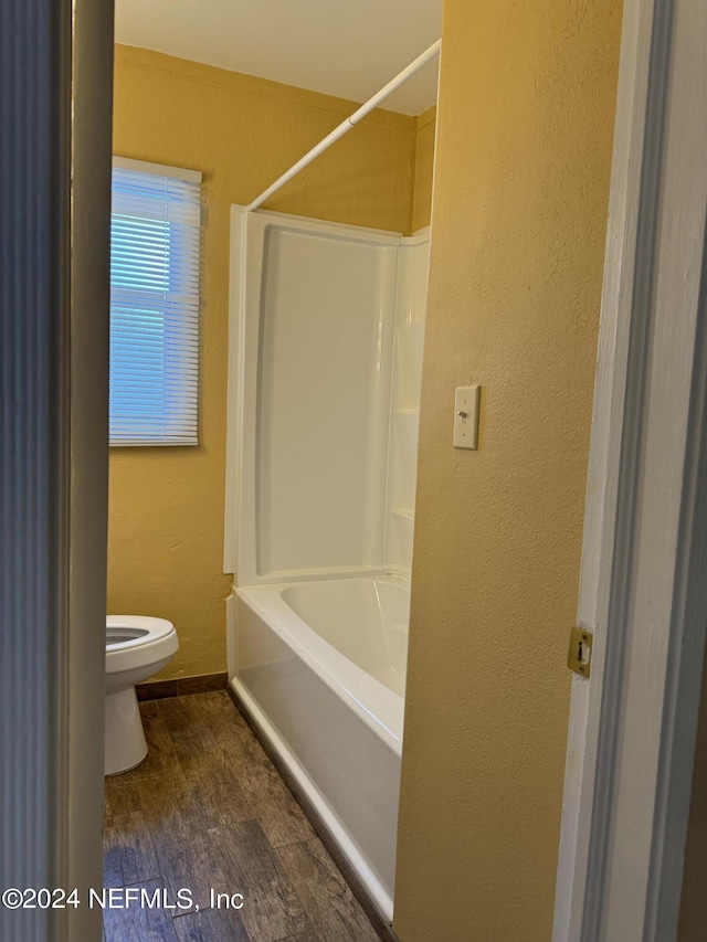 bathroom with toilet, shower / tub combination, and hardwood / wood-style floors