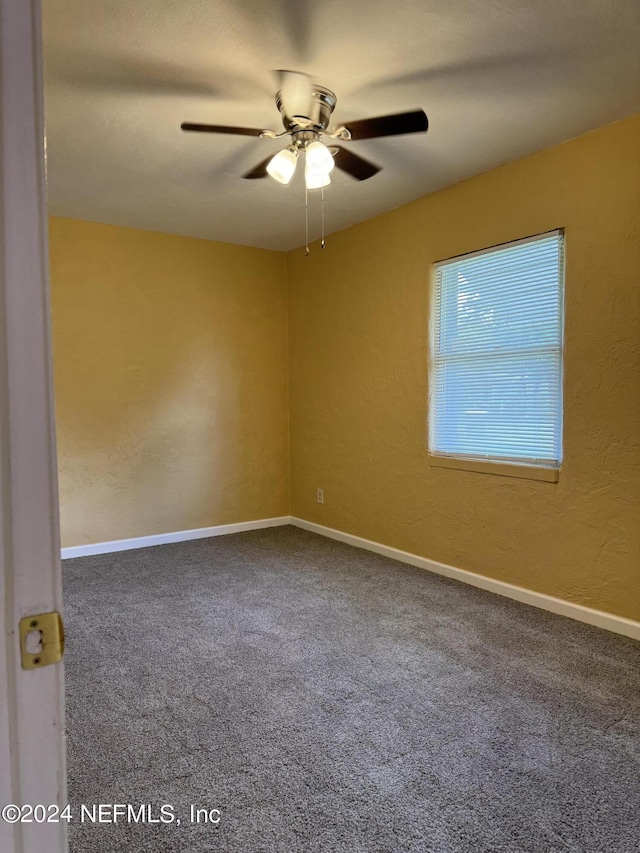 spare room with carpet floors and ceiling fan