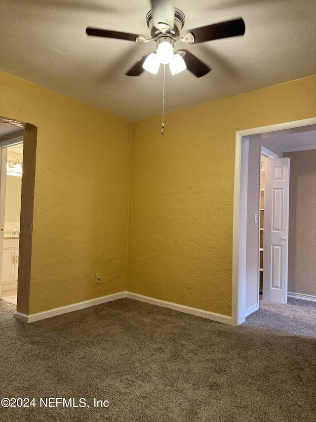 unfurnished room featuring ceiling fan and carpet