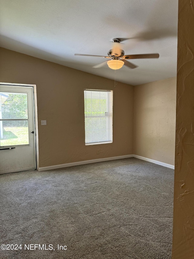 carpeted spare room with lofted ceiling, ceiling fan, and plenty of natural light