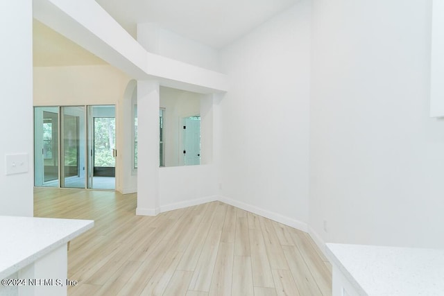 spare room featuring a high ceiling and light hardwood / wood-style floors