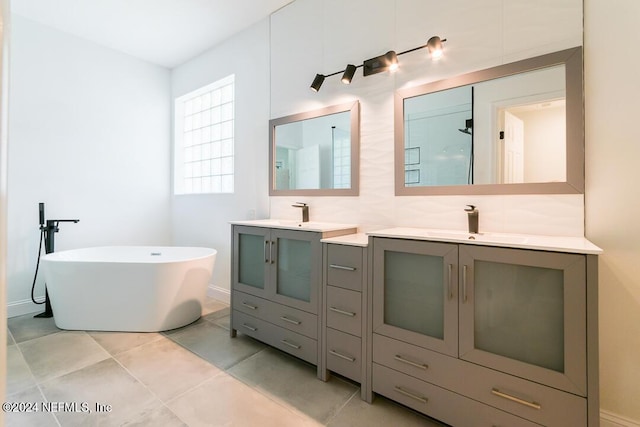 bathroom featuring tasteful backsplash, vanity, a washtub, and tile patterned floors