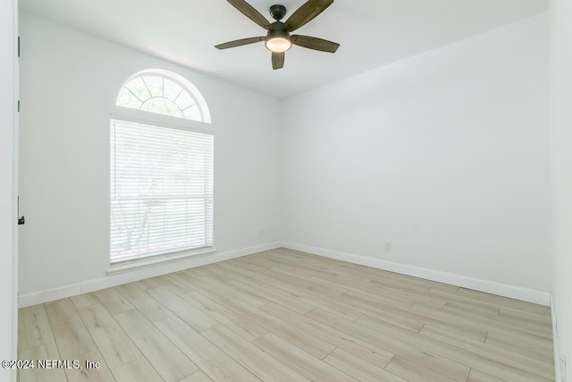 empty room with ceiling fan, a healthy amount of sunlight, and light hardwood / wood-style flooring