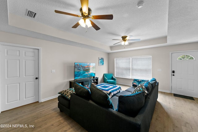 living room with hardwood / wood-style floors, a textured ceiling, and ceiling fan