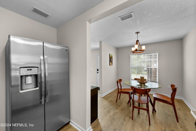 kitchen featuring light wood-style flooring, visible vents, baseboards, and stainless steel fridge with ice dispenser