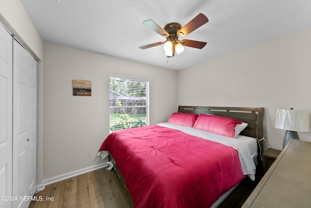 bedroom with a textured ceiling, a closet, wood finished floors, and baseboards