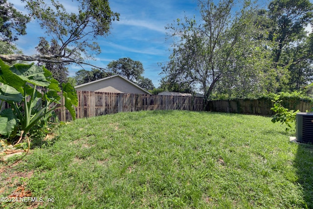 view of yard featuring fence private yard and central air condition unit