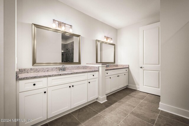 36247 Pitch Ln, Hilliard, FL 32046 - bathroom with a shower stall, baseboards, two vanities, and a sink