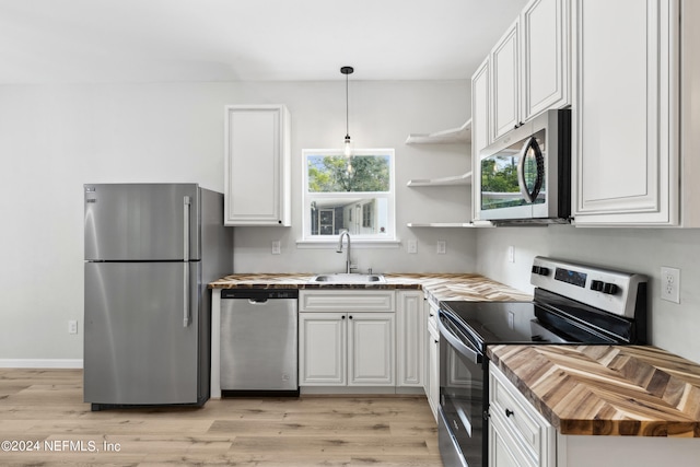 kitchen featuring sink, appliances with stainless steel finishes, light hardwood / wood-style floors, and white cabinetry