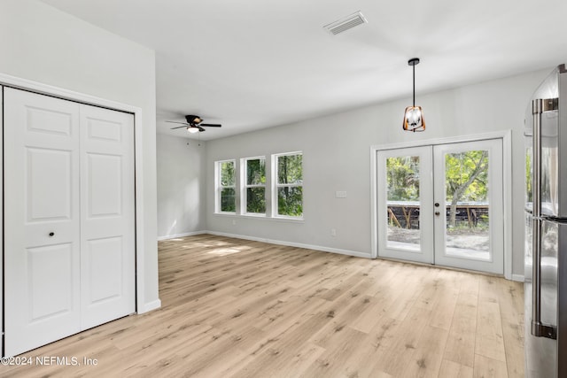 unfurnished living room featuring french doors, ceiling fan, and light hardwood / wood-style floors