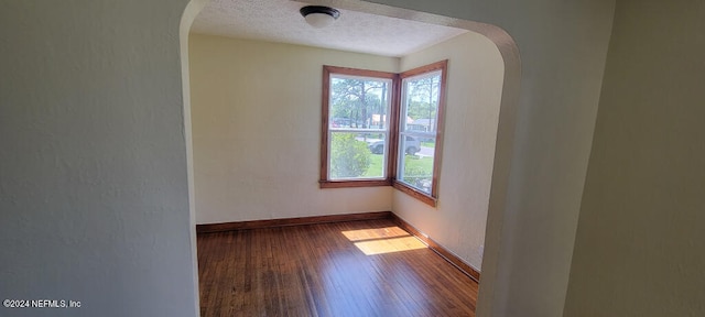 unfurnished room featuring hardwood / wood-style flooring and a textured ceiling