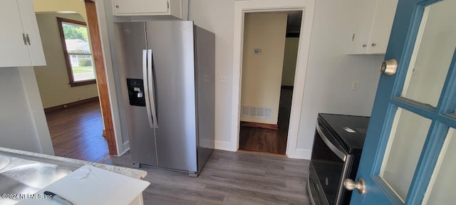 kitchen featuring white cabinetry, stainless steel fridge, and light hardwood / wood-style flooring