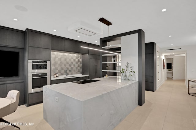 kitchen featuring sink, light stone counters, hanging light fixtures, black electric cooktop, and kitchen peninsula