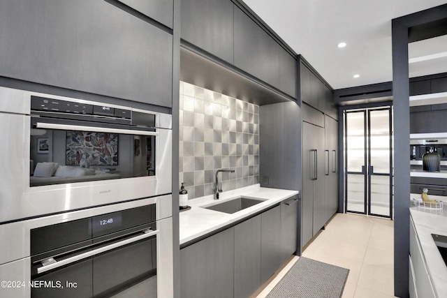 kitchen with sink, light tile patterned floors, and double oven