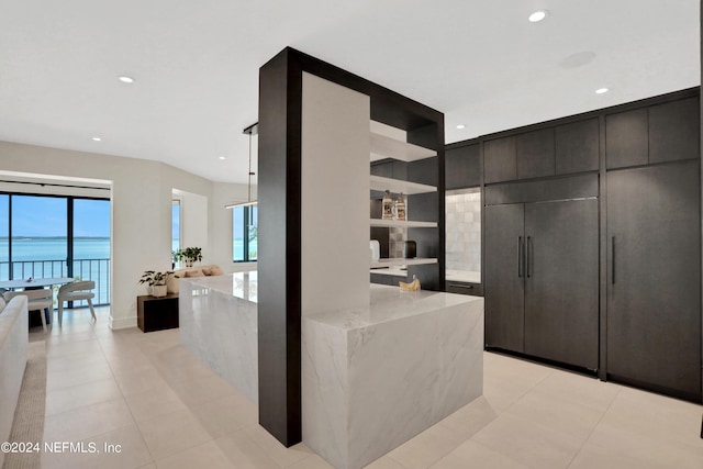 interior space featuring light tile patterned floors and a water view