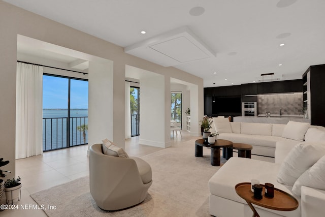 living room featuring a water view and light tile patterned flooring