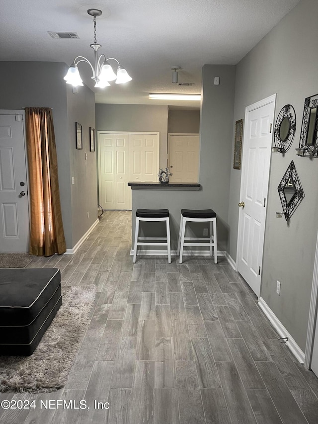 kitchen featuring hanging light fixtures, a breakfast bar, and a notable chandelier