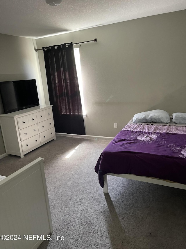 carpeted bedroom featuring a textured ceiling