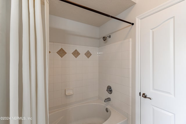 full bath with a textured ceiling and shower / bath combo with shower curtain