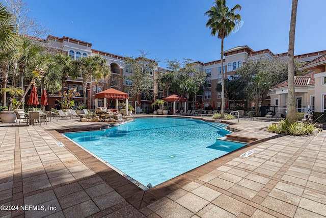 pool with a patio area and fence