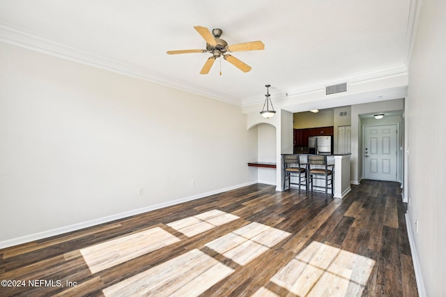 unfurnished living room with ceiling fan, dark wood-type flooring, visible vents, baseboards, and crown molding