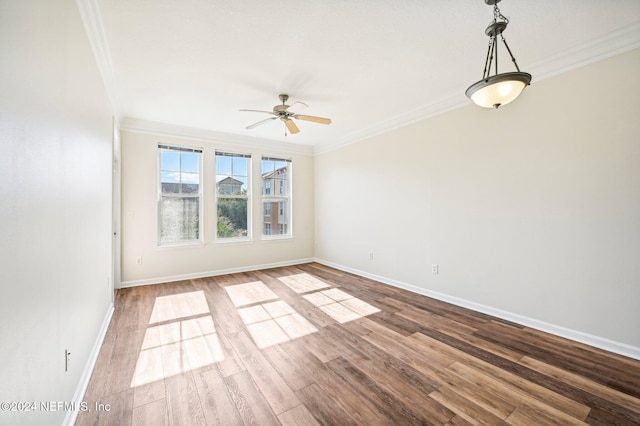 unfurnished room featuring hardwood / wood-style flooring, ceiling fan, and crown molding