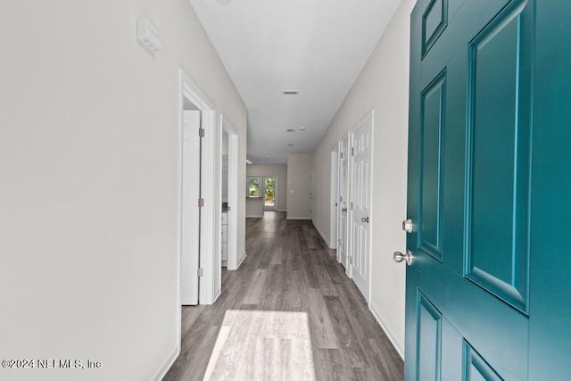 hallway featuring baseboards and wood finished floors