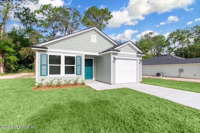 view of front of home with a garage, concrete driveway, and a front lawn