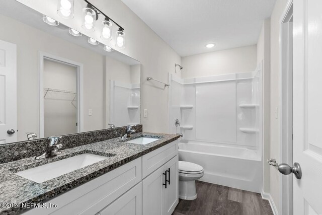 full bathroom with hardwood / wood-style flooring, shower / bath combination, toilet, and double sink vanity