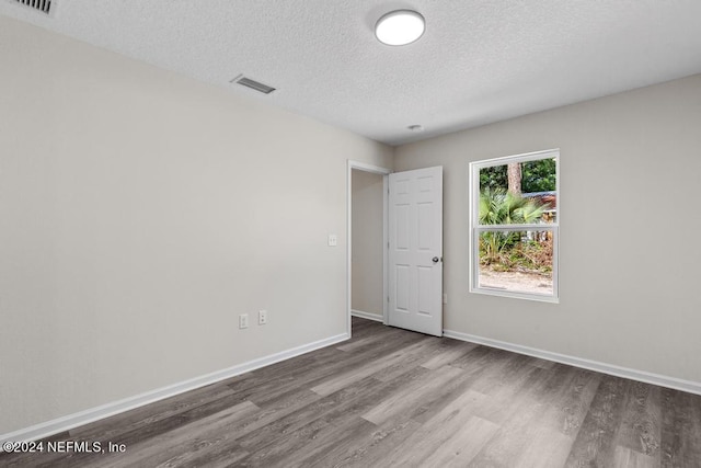 unfurnished room featuring a textured ceiling and hardwood / wood-style flooring