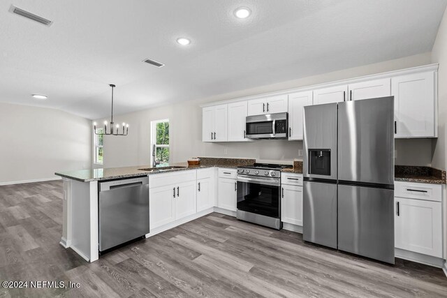 kitchen featuring kitchen peninsula, hardwood / wood-style flooring, stainless steel appliances, and white cabinets