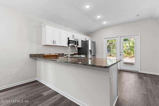 kitchen featuring white cabinetry, lofted ceiling, kitchen peninsula, dark hardwood / wood-style flooring, and stainless steel appliances