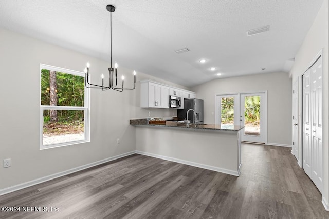 kitchen featuring stainless steel appliances, white cabinets, visible vents, and dark wood-style floors