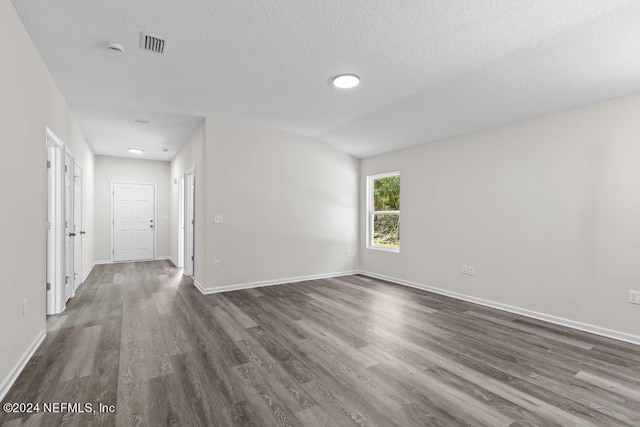 spare room featuring hardwood / wood-style flooring and a textured ceiling