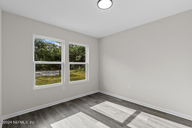 unfurnished room featuring baseboards and wood finished floors