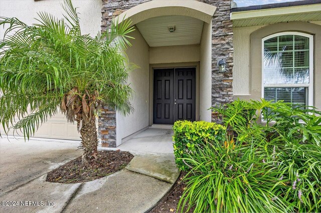 view of exterior entry featuring a garage