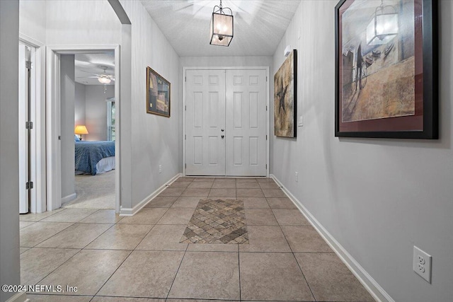 hall with light tile patterned floors and a textured ceiling