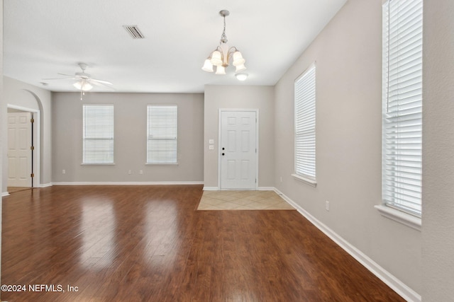 entrance foyer featuring visible vents, ceiling fan with notable chandelier, baseboards, and wood finished floors