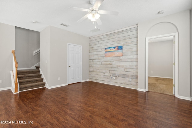 unfurnished living room with visible vents, stairway, ceiling fan, and wood finished floors