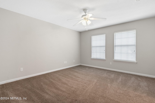 carpeted empty room featuring baseboards and ceiling fan