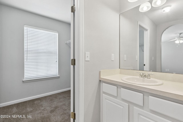 bathroom with vanity, a ceiling fan, and baseboards