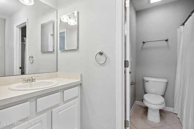 bathroom featuring tile patterned flooring, toilet, vanity, and baseboards