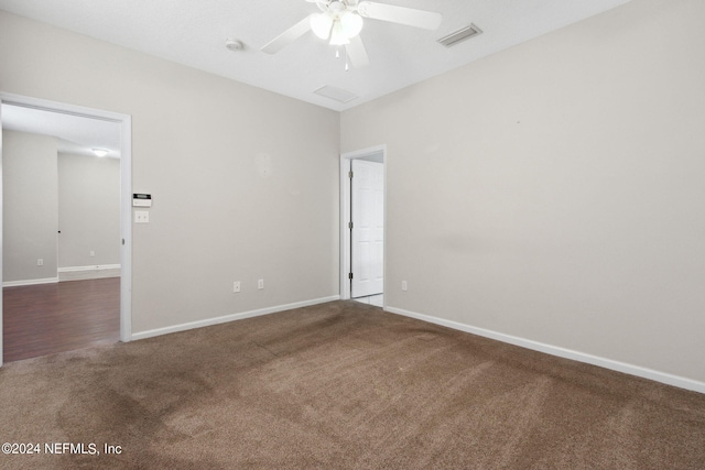 carpeted empty room featuring visible vents, baseboards, and a ceiling fan