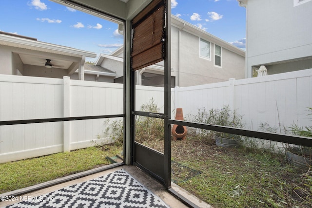 unfurnished sunroom with ceiling fan