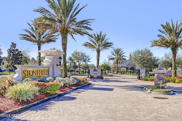 view of street featuring a gate, curbs, and a gated entry