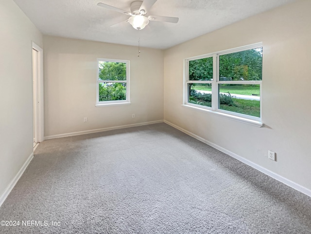 unfurnished room with ceiling fan, a textured ceiling, and carpet floors