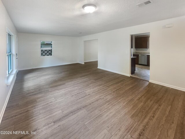 spare room featuring dark wood-type flooring and a textured ceiling