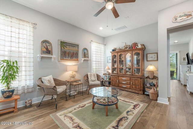 living area featuring hardwood / wood-style floors and ceiling fan