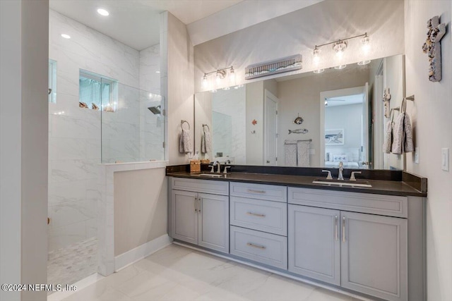 bathroom featuring tiled shower and vanity